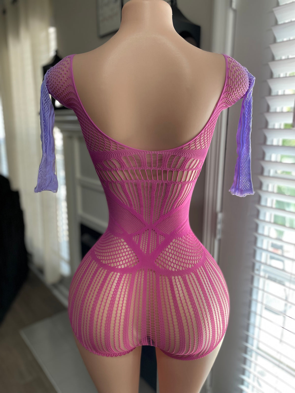 Hot pink mixed-knit fishnet mini romper back view showing spider web knit detail